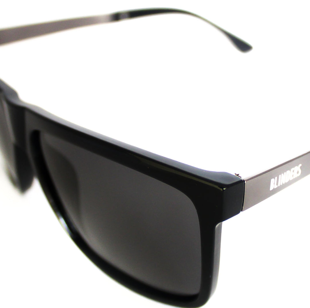 Lentes de sol Blinders Black Walker frontal con marco negro y lentes espejados negros, estilo unisex UV400